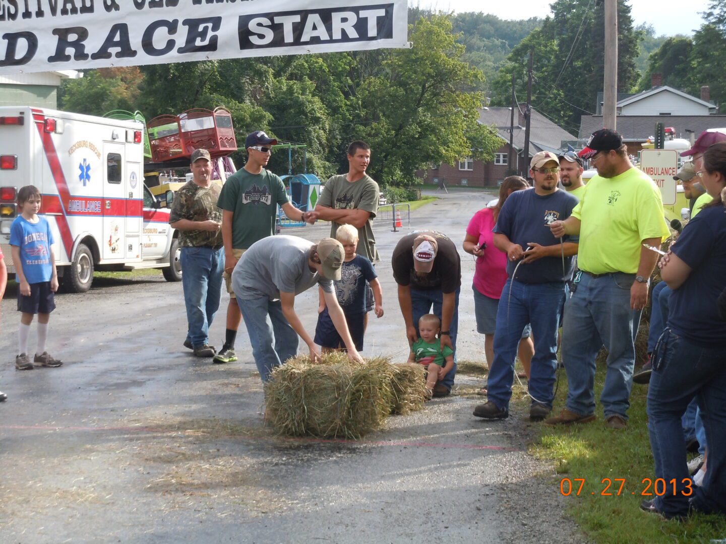 A group of people standing around hay bales.