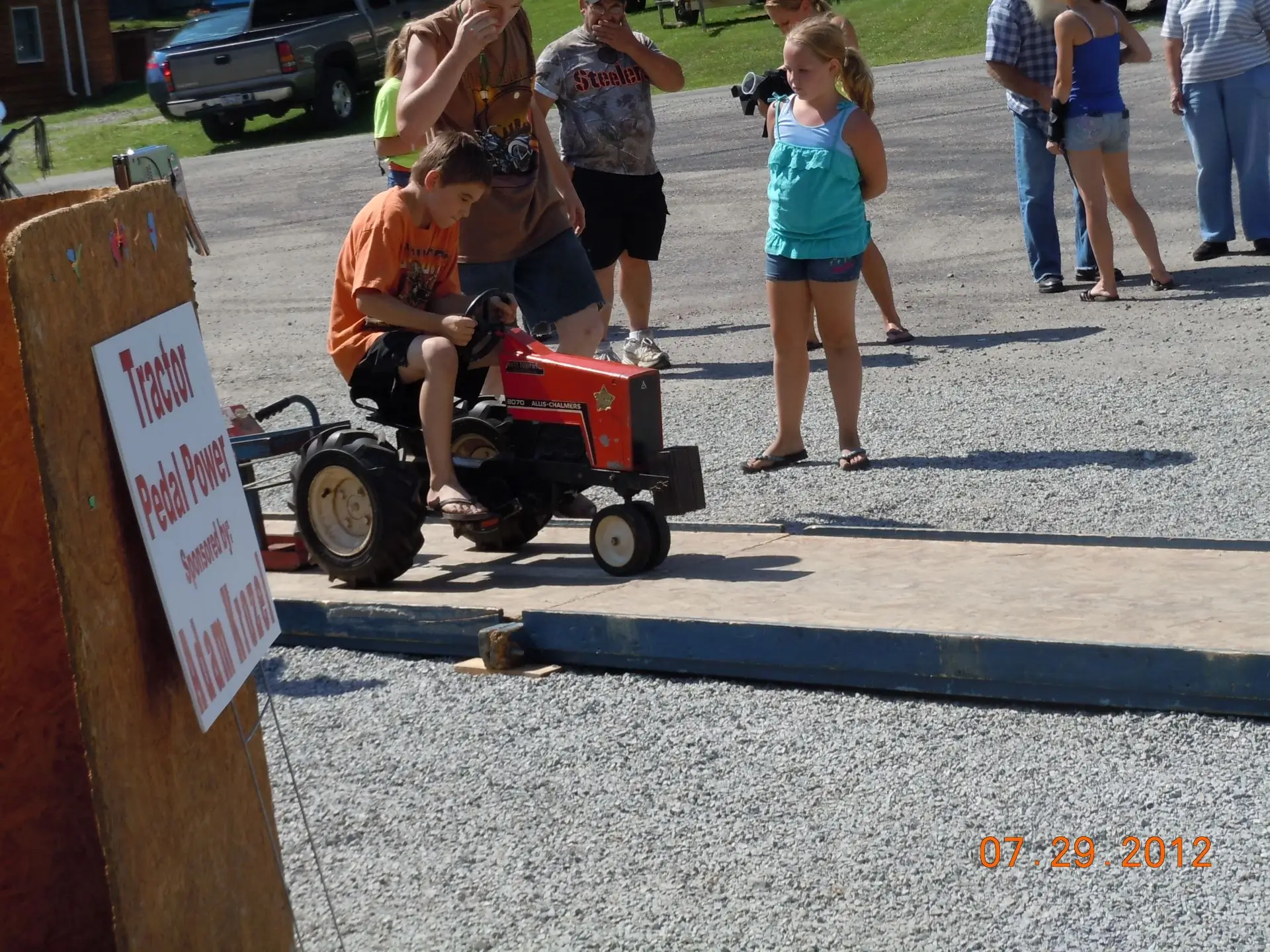 A man sitting on top of an orange tractor.